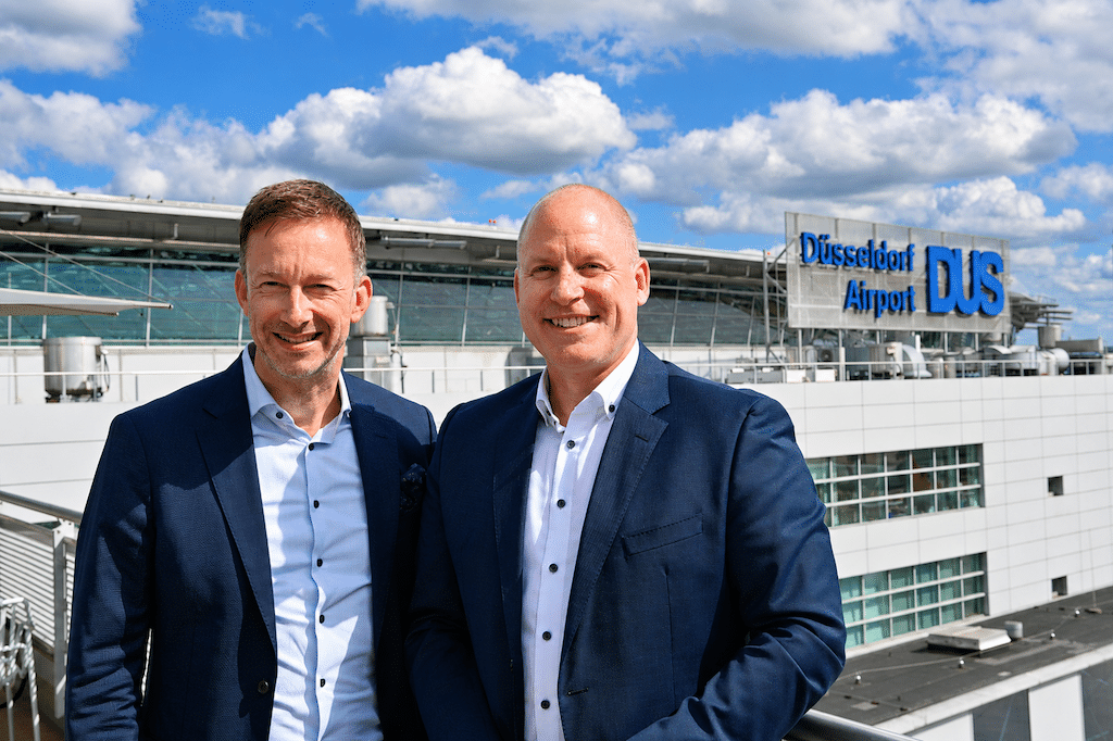 Lars Redeligx, Vorsitzender der Geschäftsführung des Düsseldorfer Flughafens, und Walter Knoll präsentieren sich auf der Terrasse der Rhein Lounge mit Blick auf den Düsseldorf Airport © Lokalbüro