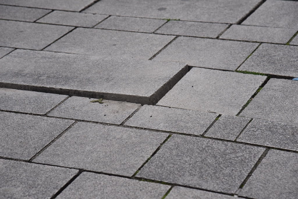 Das Pflaster in der Düsseldorfer Altstadt bereitet seit Jahren Probleme. Immer wieder lockern sich Pflastersteine oder stehen hoch, sodass nahezu täglich Reparaturen erforderlich sind. Das Foto zeigt einen typischen Schadensbereich mit abgesackten und hochstehenden Steinen, der eine Stolpergefahr darstellt. © Lokalbüro